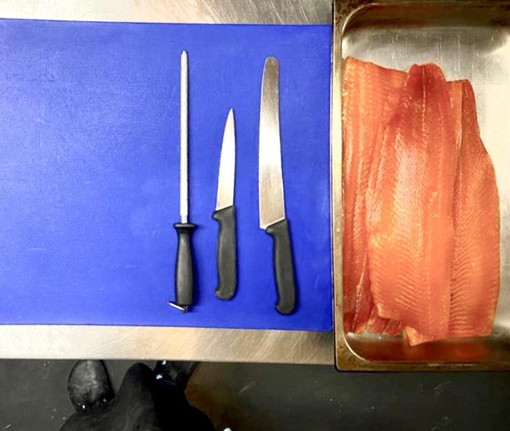 A chef's work station with fish knives and filleted trout