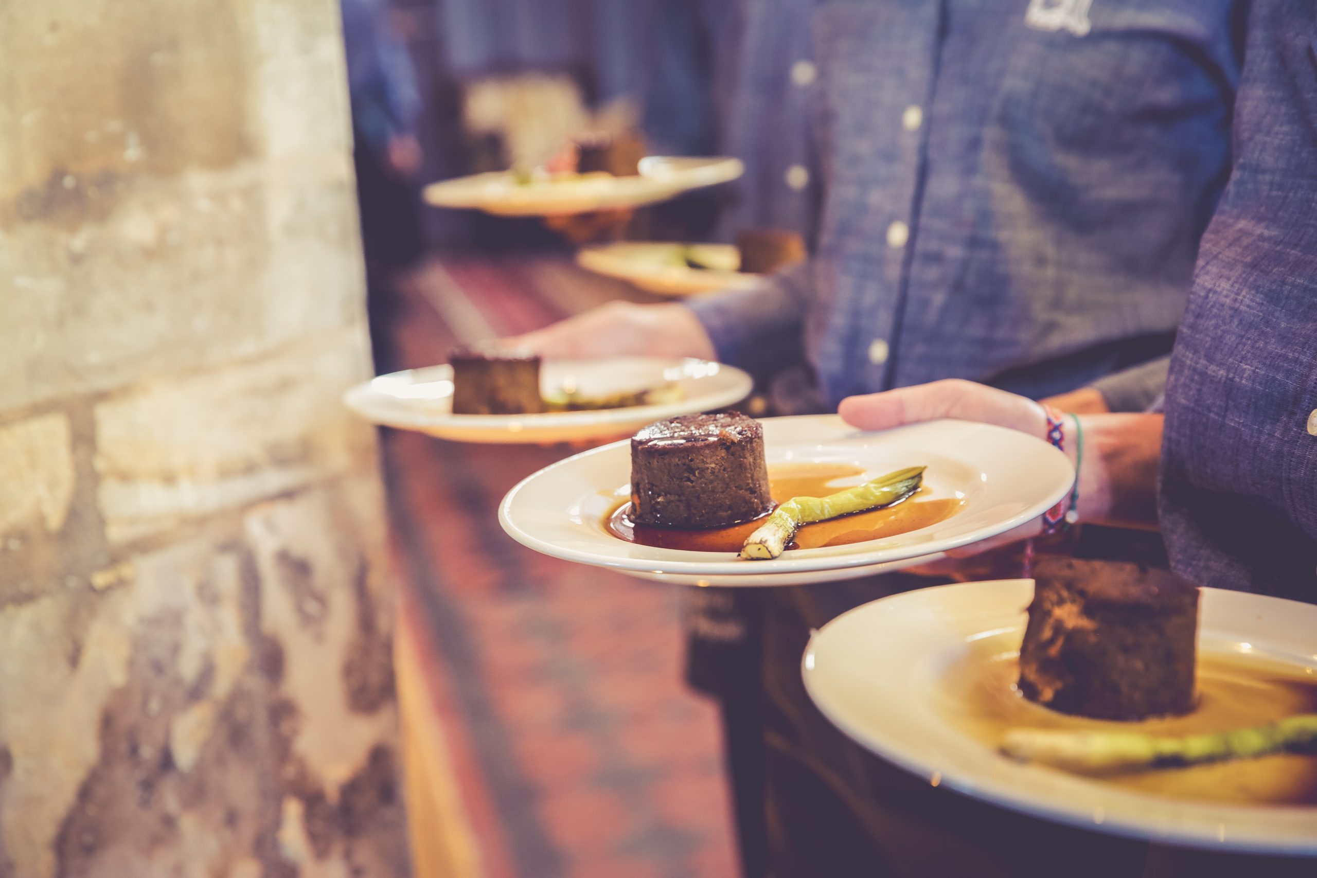 Serving plated mains with sharing sides at The Mount Without wedding venue Bristol