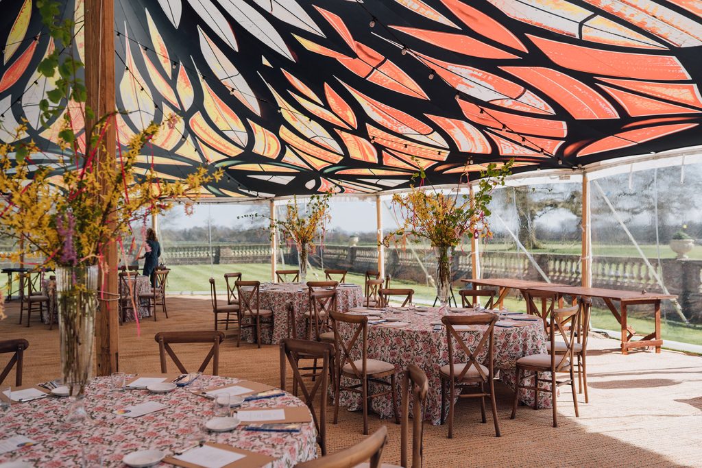 A marquee set for a wedding with a colourful roof lining